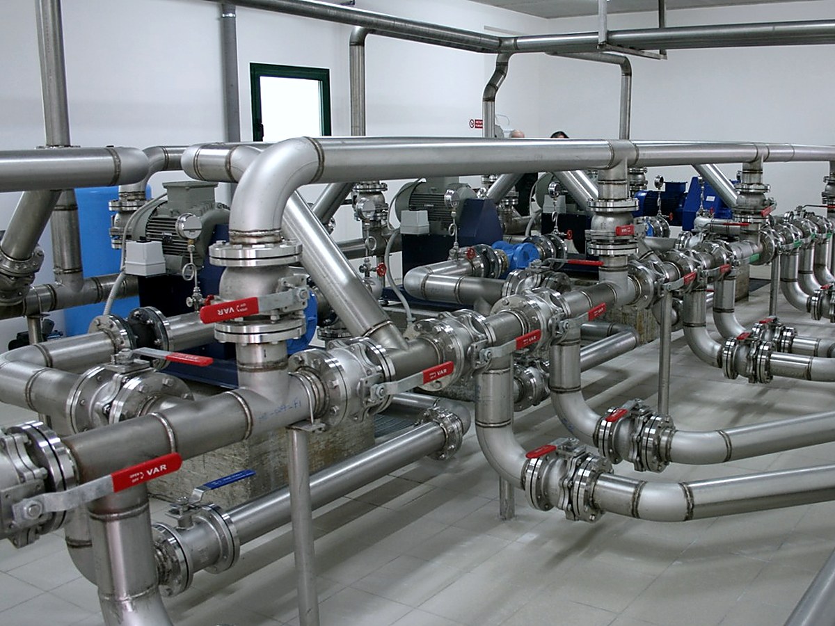 Sala pompaggio con rete di tubazioni e valvole in acciaio inox